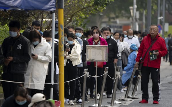 People wearing face masks stand in line for COVID-19 tests at a coronavirus testing site in Beijing, Wednesday, Oct. 12, 2022. A meeting of the ruling Communist Party to install leaders gives President Xi Jinping, China's most influential figure in decades, a chance to stack the ranks with allies who share his vision of intensifying pervasive control over entrepreneurs and technology development. (AP Photo/Mark Schiefelbein)