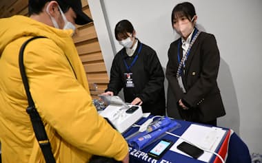 マイナカード決済でグッズを購入する男性(23日、福岡市)=画像を一部処理しています