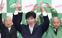 福井県知事選で初当選を決め、万歳する石田嵩人氏(25日深夜、福井市)=共同