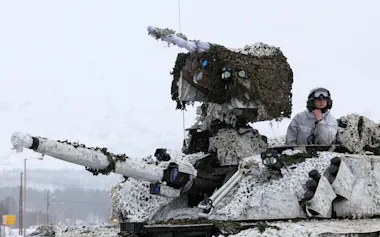 ロシアのウクライナ侵略を受け、北極圏で行われたNATO主導の大規模軍事演習に参加するノルウェー軍の装甲車両と兵士(2022年3月、ノルウェー北部)=ロイター