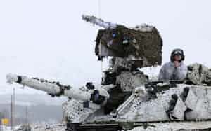 ロシアのウクライナ侵略を受け、北極圏で行われたNATO主導の大規模軍事演習に参加するノルウェー軍の装甲車両と兵士(2022年3月、ノルウェー北部)=ロイター ロシアのウクライナ侵略を受け、北極圏で行われたNATO主導の大規模軍事演習に参加するノルウェー軍の装甲車両と兵士(2022年3月、ノルウェー北部)=ロイター