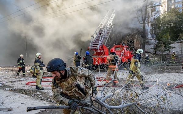 ロシアのドローン攻撃を受けたキーウ市内の住宅から女性を救助する消防士ら（17日）=ロイター