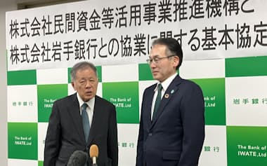 記者団の質問に答える高橋PFI推進機構会長兼社長㊧と岩山・岩手銀頭取(28日、盛岡市の岩手銀行本店)