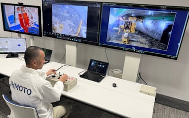 岡山市内のオペレーターがモニター画面を見ながら新潟の土木工事現場の地下で作業する掘削機を動かした