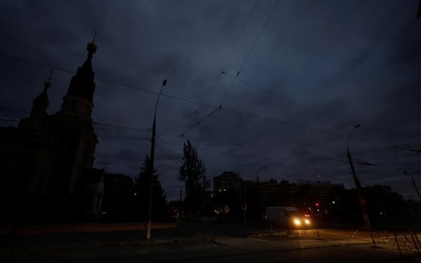 節電が呼びかけれられ、明かりの乏しい道路を通過する車両（20日夜、ミコライウ州）＝ロイター