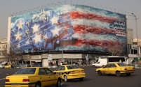 テヘラン市内の建物に掲げられた反米の看板(26日)=WANA・ロイター