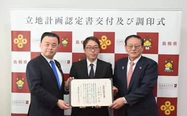 立地計画認定書の交付を受け、記念撮影に応じるひろせプロダクトの鉄本学社長㊥ら(29日、島根県庁)