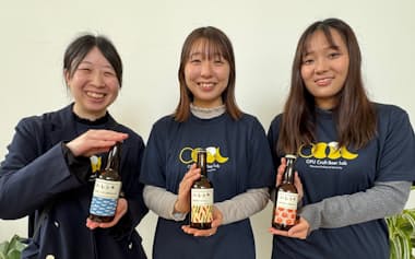 開発に関わった3種類のクラフトビールを手にする岡山県立大学の学生グループのメンバー