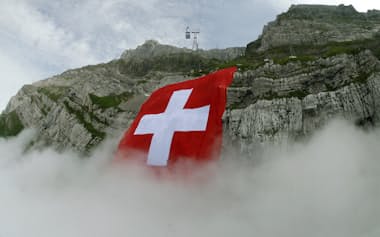 The world's largest Swiss flag is fixed by climbers on Mount Saentis (2502 meter/8209 feet above sea level) near Schwaegalp in the eastern Swiss Alps July 30, 2009. The flag measures some 120 by 120 metres (394 by 394 ft.). REUTERS/Arnd Wiegmann (SWITZERLAND IMAGES OF THE DAY SOCIETY)