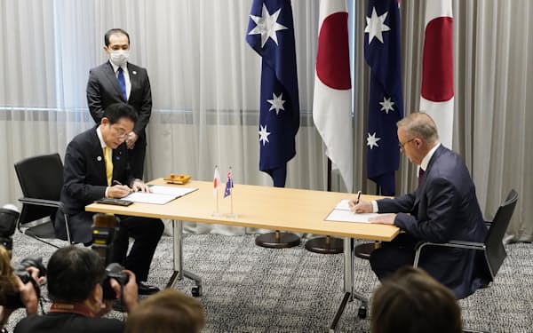 　安全保障協力に関する新たな共同宣言に署名するオーストラリアのアルバニージー首相（右）と岸田首相（22日、パース）＝共同