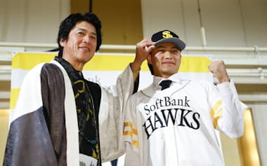 ソフトバンクへの入団記者会見でポーズをとる徐若熙投手。左は城島健司CBO(29日、福岡市)=共同