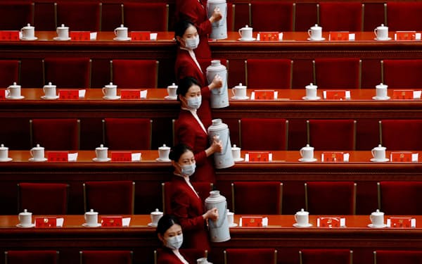 中国共産党の第20回党大会の会場で開会前に飲み物の準備をする女性たち（16日、北京）＝ロイター