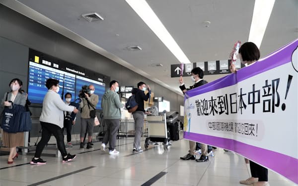 香港線復便初便の到着を空港スタッフが横断幕で出迎えた