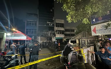 火災のあったビルには鎮火後も警官などが詰めかけていた(25年12月、ジャカルタ)