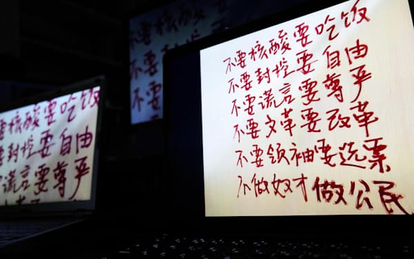 SNSで拡散された「自由がほしい」などと中国語で書かれた落書きの写真を表示する画面＝共同