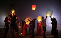 インドの西ベンガル州ライガンジで、ディワリを祝ってランタンを飛ばす人々。宗教の枠を超えて5日間にわたって祝われるこの「光の祭典」は、米国の感謝祭やクリスマスに匹敵する、インドにおける最大規模の祭りだ（Photograph by Rupak de Chowdhuri, Reuters）