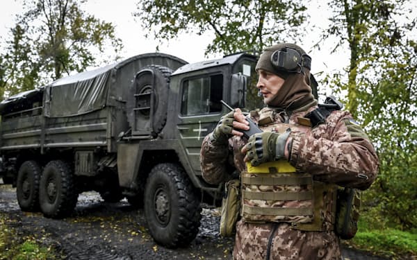 ドイツ製の榴弾砲を扱うウクライナの兵士。厳冬期のウクライナでは耐寒装備が死命を決する＝ＡＰ