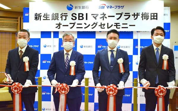 共同店舗の開業を祝う新生銀行の鍵田裕之常務執行役員（左から2人目）とSBIマネープラザの太田智彦社長（左から3人目）ら（1日、大阪市）