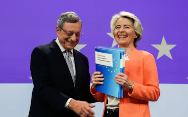 ドラギ氏(左)は規制の見直しなどEUの競争力強化に向けた報告書をまとめ、フォンデアライエン氏に渡した(24年9月、ブリュッセル)=ロイター