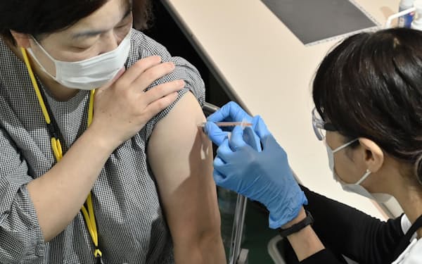 オミクロン株「BA.4」「BA.5」に対応した新型コロナワクチンの接種を受ける女性（14日午前、都庁）
