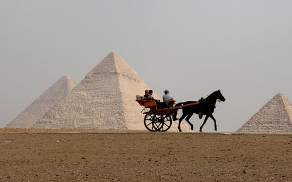 Tourists ride a horse-drawn cart in front of the Pyramids in Giza, on the outskirts of Cairo, Egypt, October 27, 2022. REUTERS/Mohamed Abd El Ghany     TPX IMAGES OF THE DAY