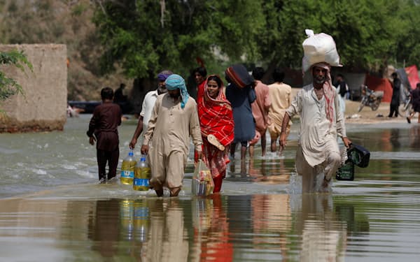 洪水を受けた地域を歩くパキスタンの住民（９月）＝ロイター