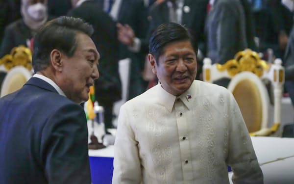 韓国の尹錫悦（ユン・ソンニョル）大統領㊧と話すフィリピンのマルコス大統領（11日、プノンペン）＝ＡＰ