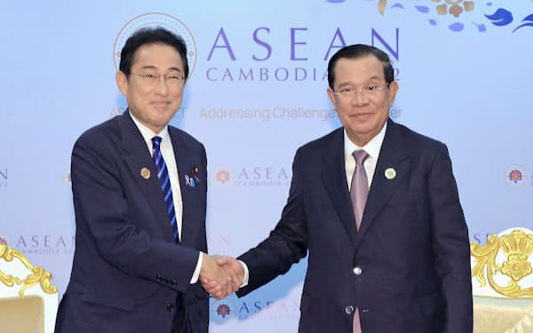 会談を前にカンボジアのフン・セン首相（右）と握手する岸田首相（12日、プノンペン）＝代表撮影