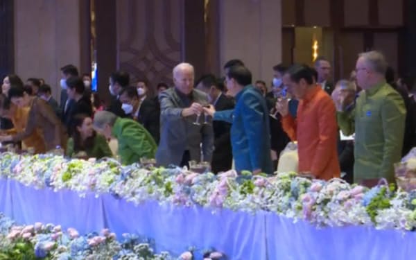 12日、ＡＳＥＡＮ関連首脳会議の公式晩さん会で乾杯するバイデン米大統領（中央左）と中国の李克強首相（カンボジア国営テレビの中継映像）