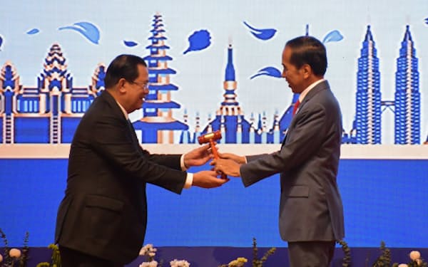 ASEAN関連首脳会議の閉幕式でインドネシアのジョコ大統領㊨に木づちを渡すカンボジアのフン・セン首相（13日、プノンペン）