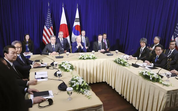 日米韓首脳会談に臨む岸田首相（右手前）、バイデン米大統領（奥中央）、尹錫悦韓国大統領（左端）＝代表撮影・共同