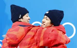 男子スーパー団体の競技を終え、抱き合う小林陵侑選手㊧と二階堂蓮選手(プレダッツォ)=共同 男子スーパー団体の競技を終え、抱き合う小林陵侑選手㊧と二階堂蓮選手(プレダッツォ)=共同
