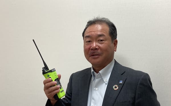 米国の公共安全分野向けの新型無線機を手に取る鈴木昭取締役