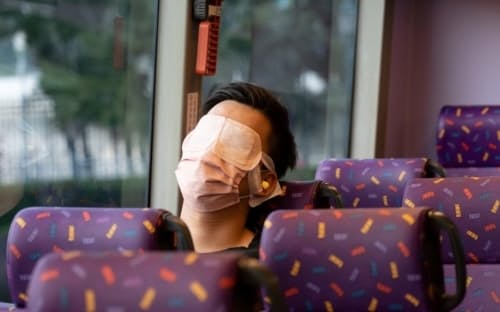 2021年11月14日、「静かなバス」で眠る乗客。香港では、不眠症の治療として「どこにも行かない」バスツアーが販売された。(PHOTOGRAPH BY BERTHA WANG, AFP/GETTY IMAGES)