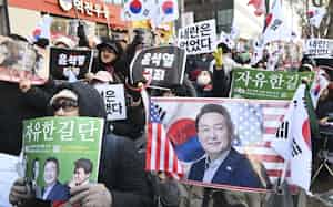 ソウル中央地裁の近くで尹前大統領の無罪を訴える人々(19日)=共同 ソウル中央地裁の近くで尹前大統領の無罪を訴える人々(19日)=共同