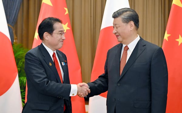 会談の冒頭、中国の習近平国家主席（右）と握手する岸田首相（17日、バンコク）＝代表撮影・共同