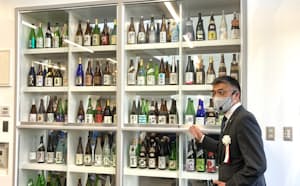 新潟県内の全89の酒蔵が造った酒瓶を飾る1階のスペース（平田副センター長）=県提供