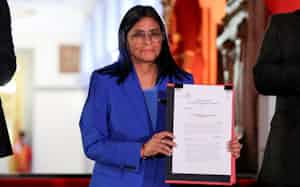 政治犯恩赦法の文書を手にするロドリゲス暫定大統領(19日、ベネズエラの首都カラカス)=共同 政治犯恩赦法の文書を手にするロドリゲス暫定大統領(19日、ベネズエラの首都カラカス)=共同