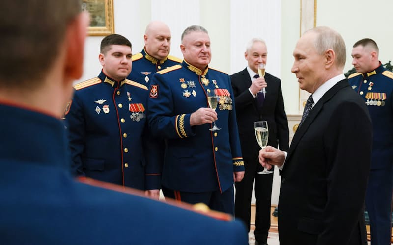 勲章授与式で軍将校らと乾杯するロシアのプーチン大統領㊨(23日、モスクワ)=ロイター 勲章授与式で軍将校らと乾杯するロシアのプーチン大統領㊨(23日、モスクワ)=ロイター