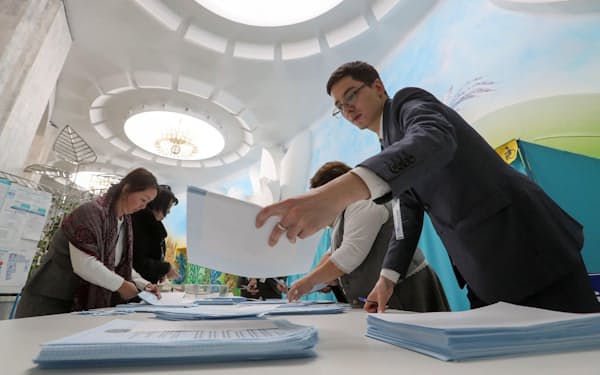 20日、カザフスタン・アルマトイで、大統領選の票を数える選挙管理当局の職員ら＝ロイター