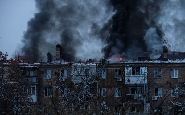ロシアのミサイル攻撃を受け黒煙が上がるキーウ近郊の住宅（23日）＝ロイター