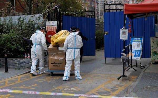 新型コロナウイルス対策により封鎖された地区で物資を運ぶ人々（9日、北京市）=ロイタ―