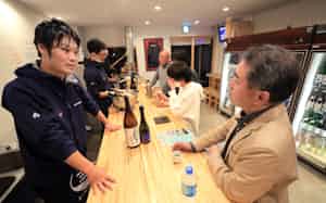 SakeBase代表の宍戸涼太郎さん(左)の店は夜は角打ちになる