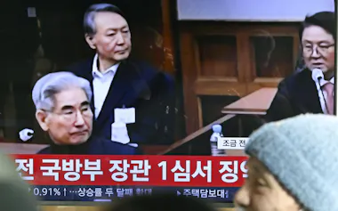ソウル駅のテレビに映し出された尹錫悦前大統領(奥)の判決公判の映像(19日)=共同