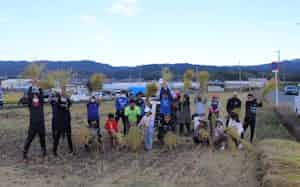 奈良クラブの選手が地域の人たちと一緒に「奈良クラブ農園」(奈良市)で稲刈りをした(10月)