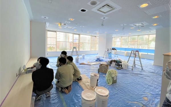 改修中の２階共用スペース。新潟工科大学の学生が作業している（24日、新潟県湯沢町）