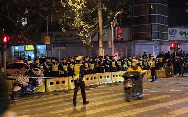 抗議活動に対応して道路を封鎖する警察関係者(27日、中国・上海市)
