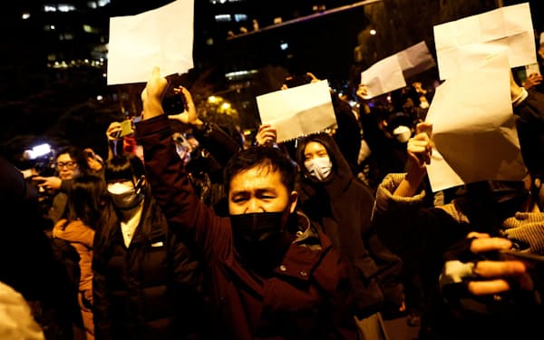 ゼロコロナ政策に白い紙を掲げて抗議する人々（27日、北京）＝ロイター・共同
