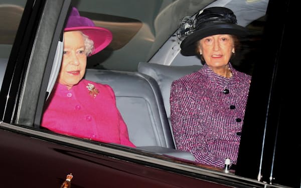 エリザベス女王（左）と並んで車に乗るハッシー氏（2011年）＝PA・AP