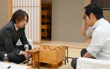 B級2組順位戦で戸辺誠七段㊨に勝ち、昇級を決めた久保利明九段(1月14日、東京都渋谷区)=日本将棋連盟提供